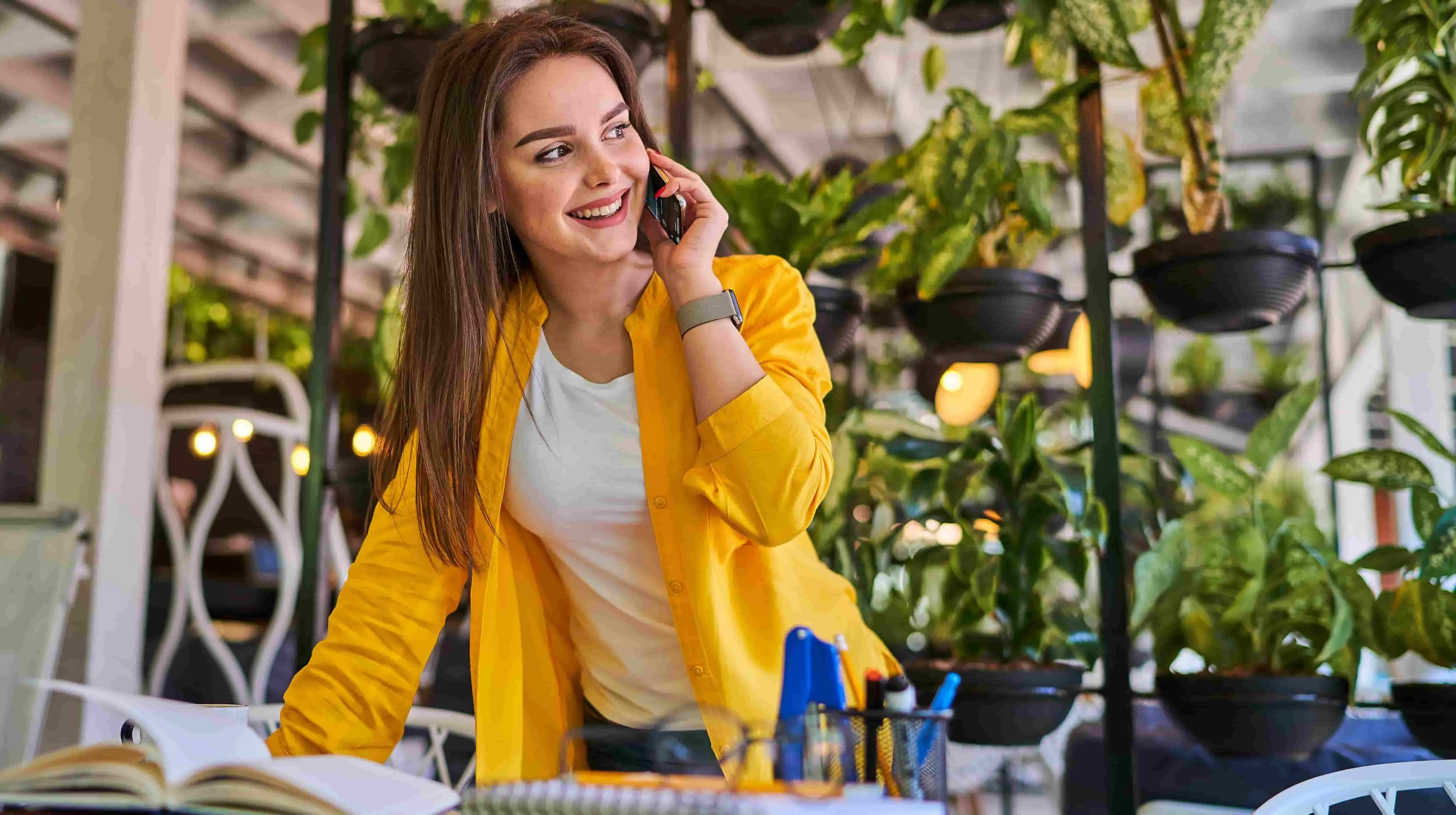 Business professional smiling during a phone conversation in a modern office