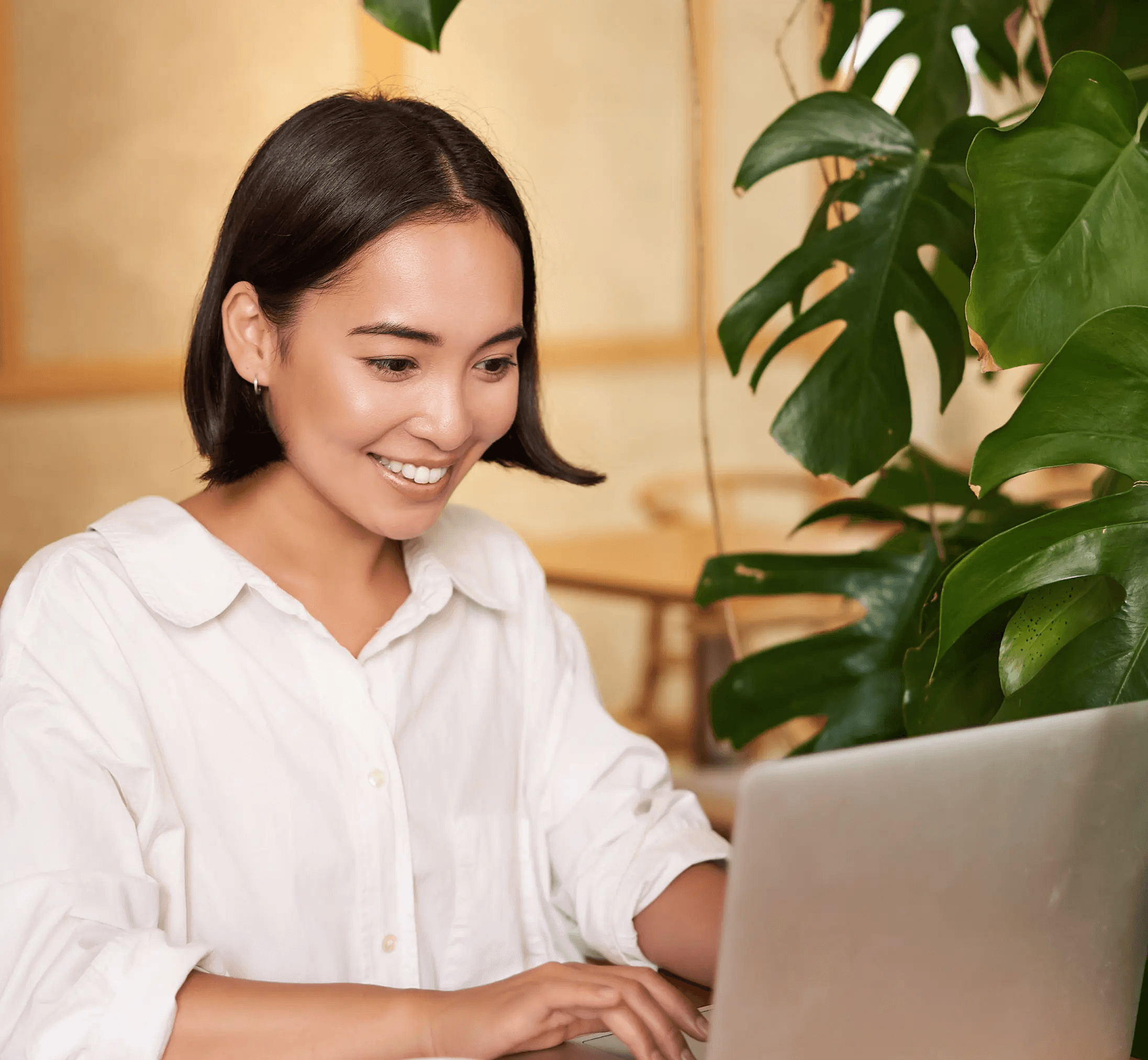 Man sitting at a laptop and a woman standing over him in an office in Dublin, laughing and collaborating, representing B2B lead generation teamwork.