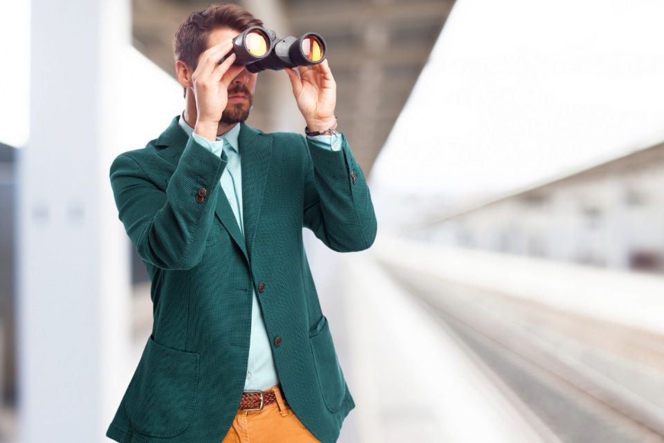 Businessman looking through binoculars, representing third-party cookies, online tracking, and over-personalised B2B marketing